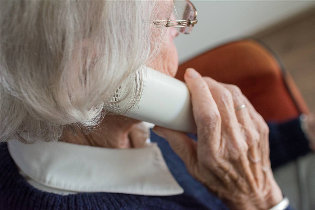 An older person speaking with a licensed agent by phone